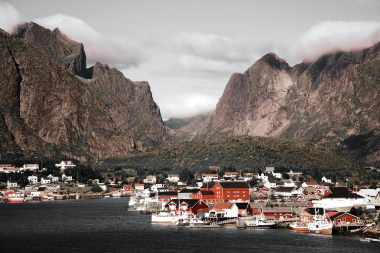 Landskapsbilde av fjell, fjord og landsby i Norge