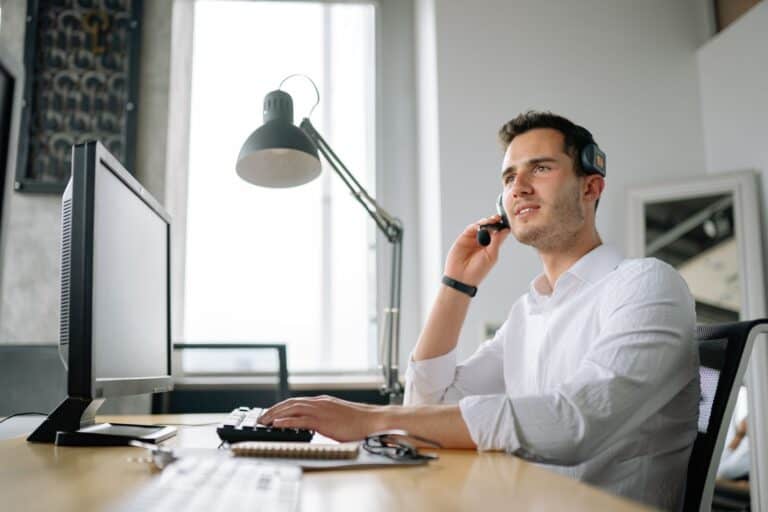 Sentralbordmedarbeider med headset besvarer kundesamtaler i bedriftens bedriftsnett
