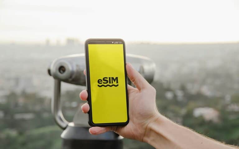 Hånd holder mobiltelefon med eSIM på skjermen – eSIM for firmatelefon