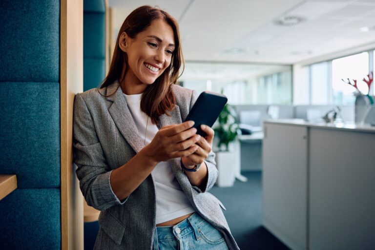 Ansatt bruker firmatelefon på kontoret – mobilabonnement for ansatte i bedrift