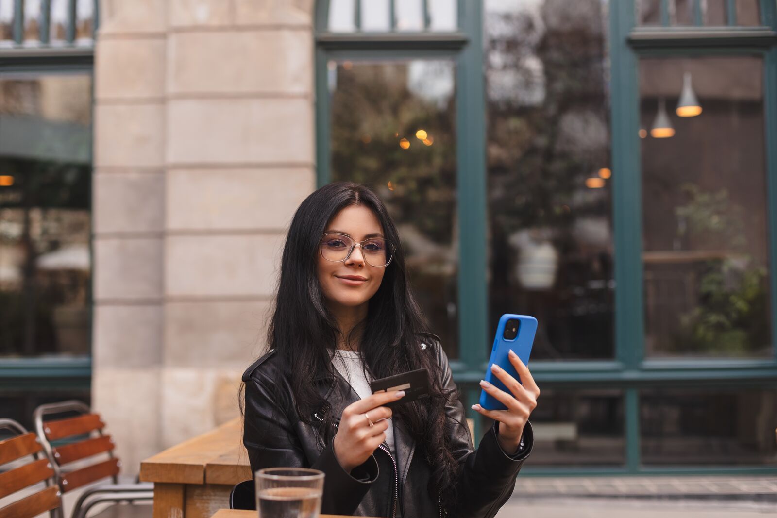 Person bruker mobiltelefon på kafé i utlandet – mobilbruk og roaming på jobbreise