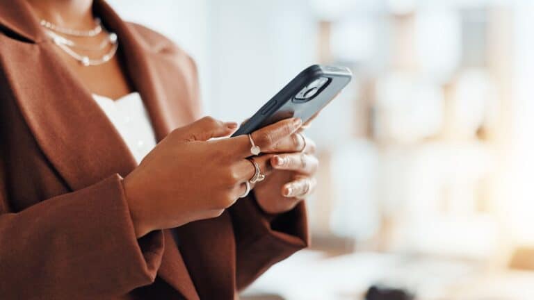 Forretningskvinne med mobiltelefon – nettoperatør og MVNO i det norske mobilmarkedet