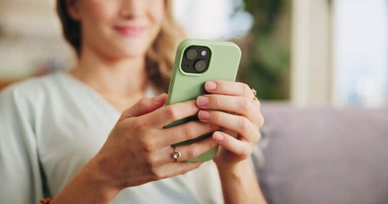 Nærbilde av mobiltelefon i hendene – tvillingkort og eSIM for bedriftsabonnement