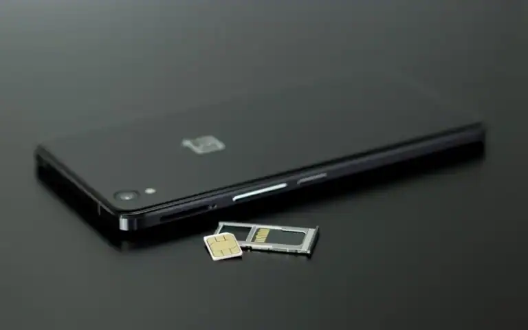 SIM-kort og SIM-skuff ved siden av en mobiltelefon