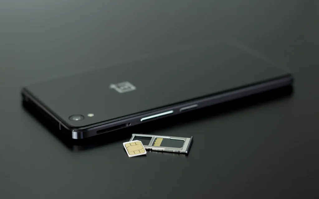 SIM-kort og SIM-skuff ved siden av en mobiltelefon – eSIM erstatter det fysiske kortet