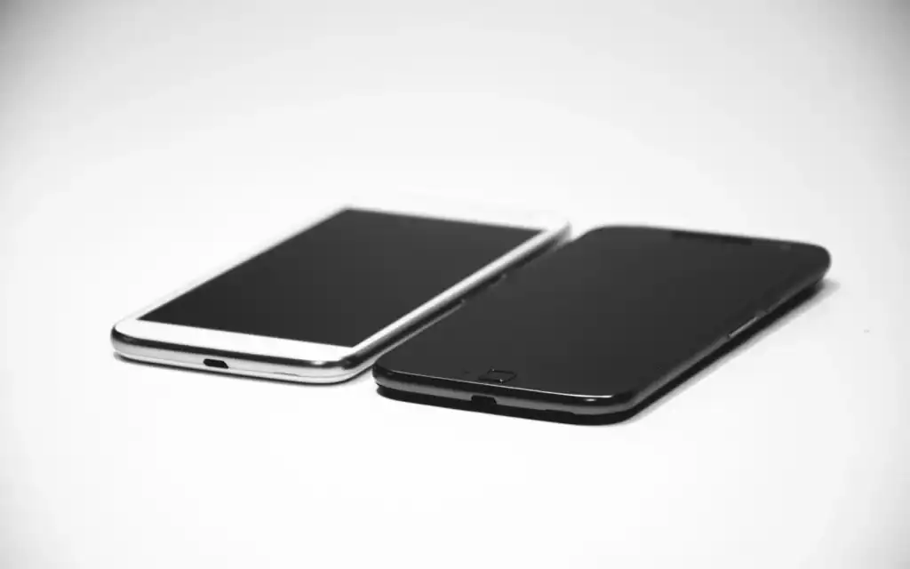 To mobiltelefoner ved siden av hverandre på en hvit flate
