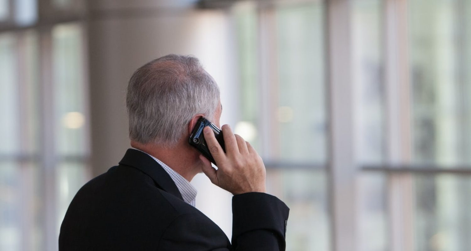 firmatelefon mann i dress snakker i en mobiltelefon