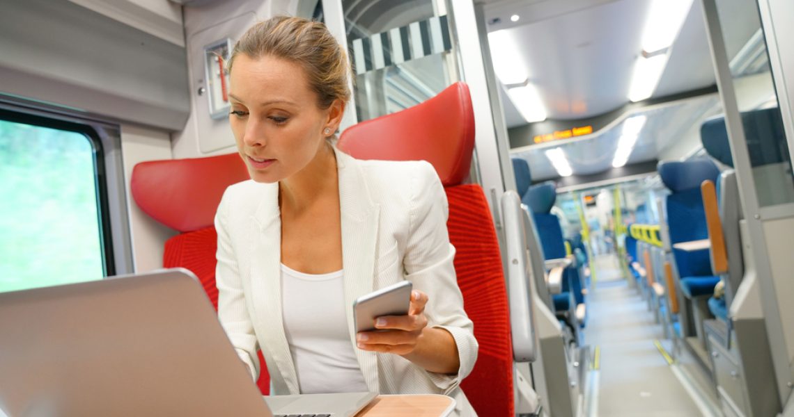 Businesswoman,In,Train,Working,On,Laptop,And,Talking,On,Phone